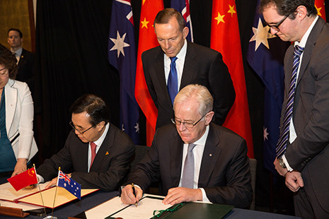 Image: Australian Trade and Investment Minister Andrew Robb and Chinese Commerce Minister Gao Hucheng signing the China-Australia Free Trade Agreement in Canberra on 17 June 2015, witnessed by Prime Minister Tony Abbott. Photo: DFAT/Andrew Taylor
