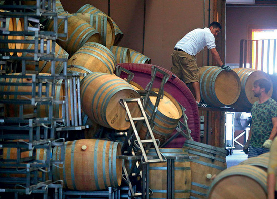 Workers move fallen wine barrels at Saintsbury Winery in Carneros following the 2014 earthquake that shook southern Napa