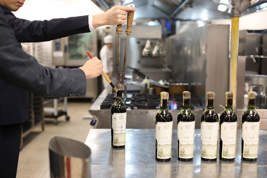 Image: Sommeliers opening the old 1949 bottles with special equipment